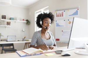 Female African American Customer Support Operator With Headset. Caller or Receptionist Phone Operator. Copy Space. Helping, Answering, Consulting. Happy Smiling African American Female Customer Support Phone Operator at Workplace