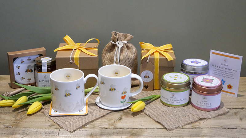 Candles, mugs, gift boxes lying on a wooden desk